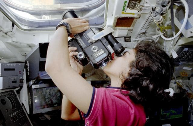 NASA image: Chawla poses in front of flight deck windows