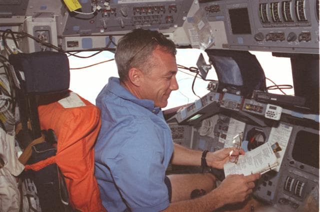 NASA image: Cdr. Wilcutt reads documents at the command station