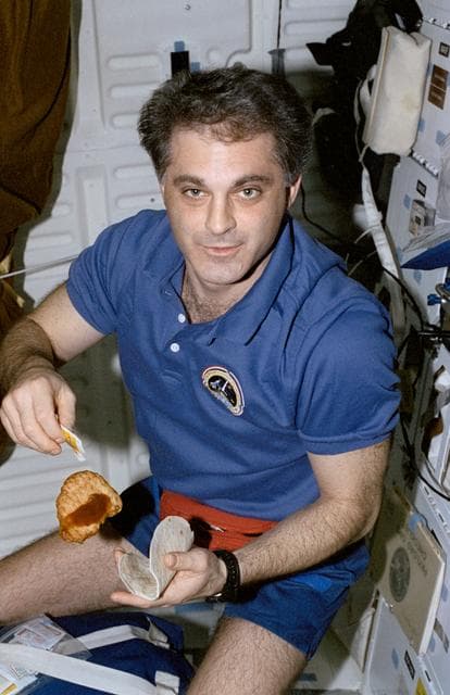 NASA image: MS Wolf eats a chicken fajita on Endeavour's middeck