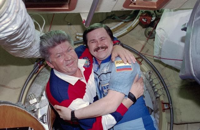 NASA image: STS-91 crew is greeted at the hatch by Mir 25 crewmembers