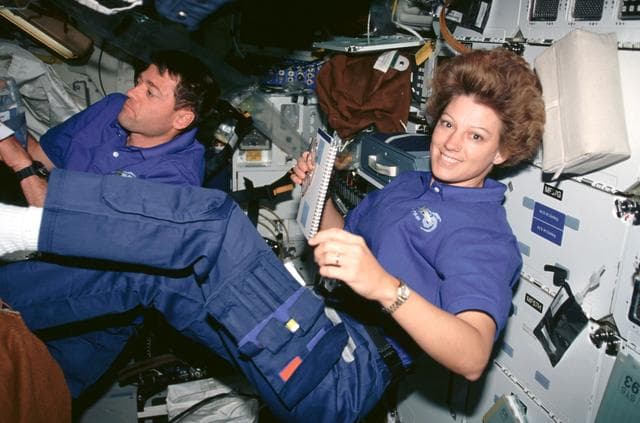 NASA image: STS-93 Commander Collins and Pilot Ashby working on the middeck of Columbia