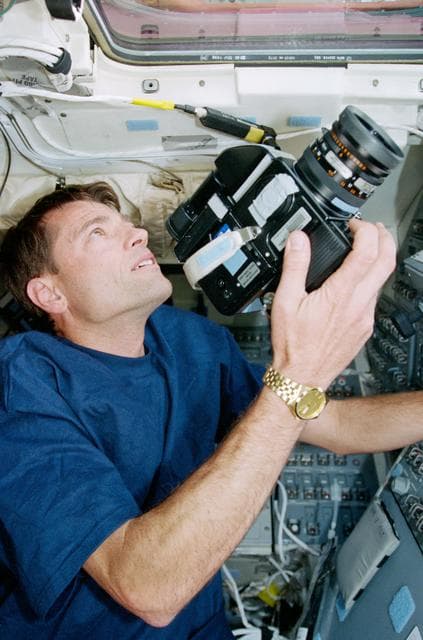 NASA image: STS-93 Pilot Ashby takes some photographs of the Earth from the flight deck