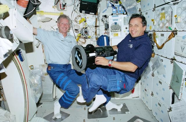 NASA image: STS-93 Tognini and Hawley pose with the SWUIS on the middeck of Columbia