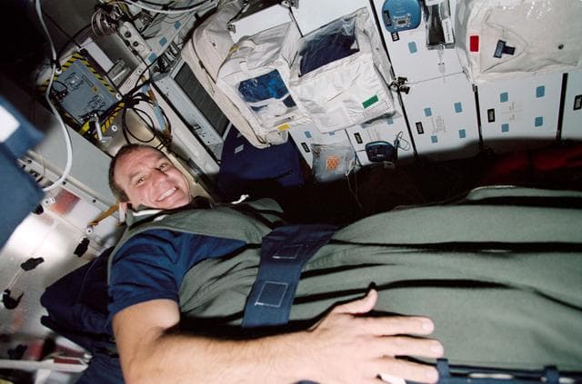 NASA image: Pilot Bloomfield in a sleep restraint on the middeck during STS-97