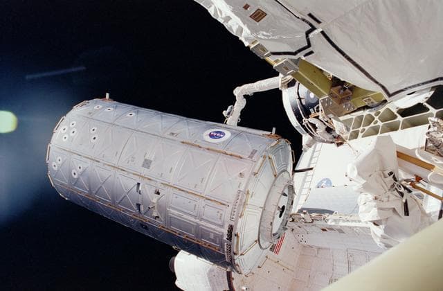 NASA image: U.S. Destiny Laboratory Module held above Atlantis' PLB