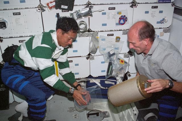 NASA image: STS-99 Mohri and Thiele change LiOH canisters on OV-105's middeck