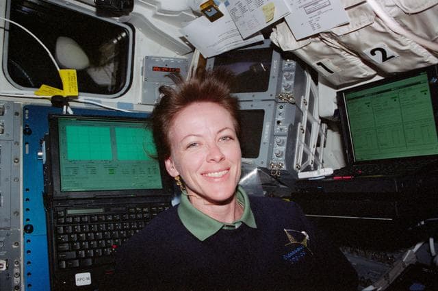 NASA image: STS-99 MS Kavandi poses by two laptop computers on OV-105's flight deck