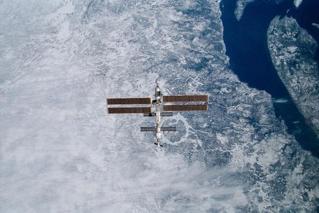 NASA image: View of the ISS with Manicouagan in the background taken during final flyaround of STS-100