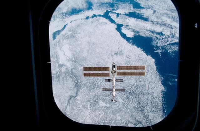 NASA image: View of the ISS with Quebec in the background taken during final flyaround of STS-100