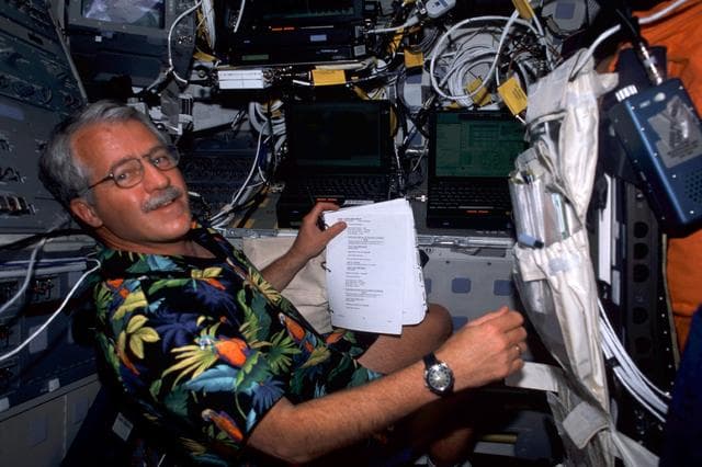 NASA image: MS Phillips goes over a checklist on the flight deck of Endeavour during STS-100