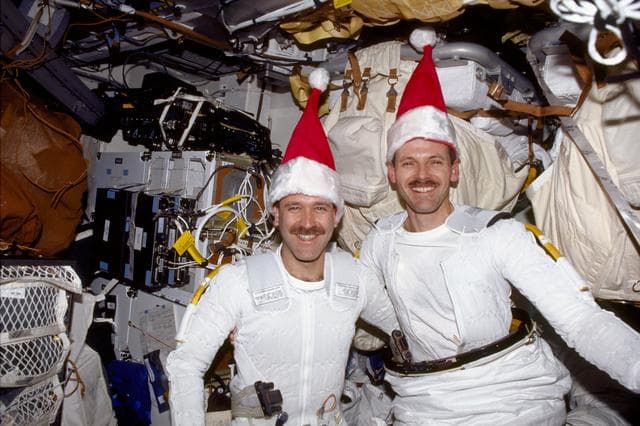NASA image: MS Grunsfeld and Smith in their EMUs in the airlock