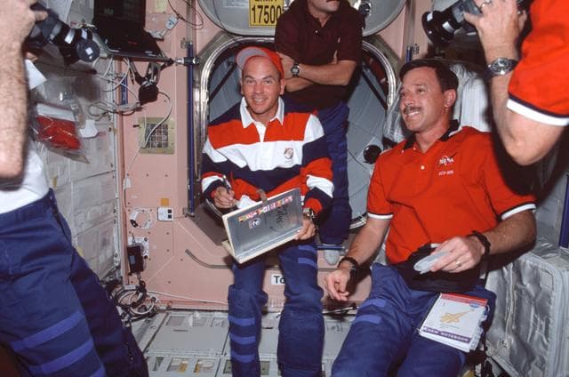NASA image: Sturckow signs the ISS ships log while Horowitz watches