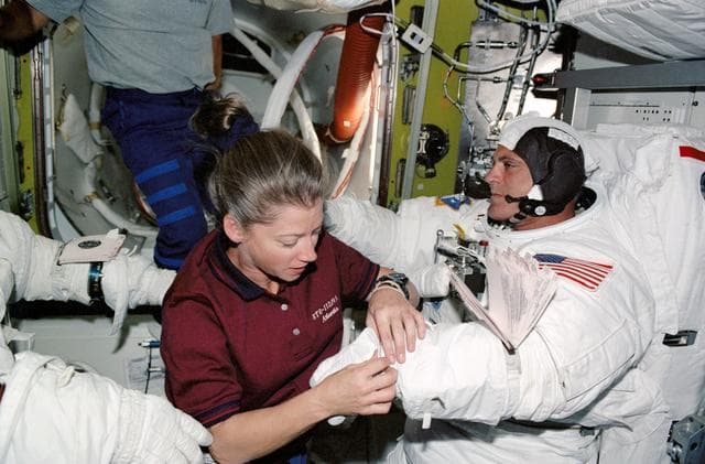 NASA image: STS-112 PLT Melroy with MS Wolf  in Quest airlock prior to EVA 2