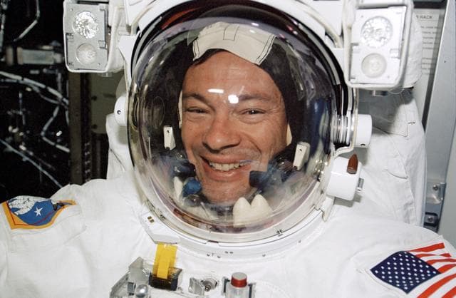 NASA image: Lopez-Alegria smiles through the helmet of his EMU during preparations for STS-113 EVA 1 in the Quest A/L